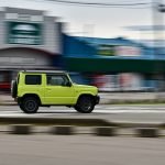 An image capturing the scorching desert landscape, with an ATV MAN dressed in lightweight, ventilated gear, donning a wide-brimmed hat and sunglasses