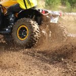 An image showcasing a brightly colored ATV and UTV zooming through a picturesque Virginia landscape