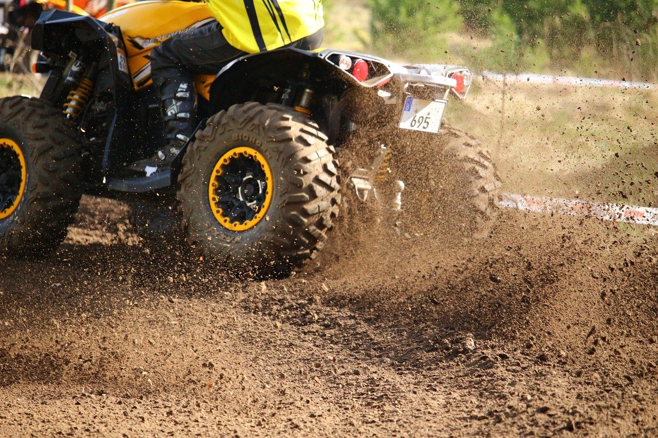 An image showcasing a brightly colored ATV and UTV zooming through a picturesque Virginia landscape