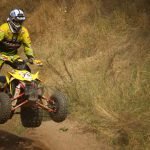 An image showcasing a Connecticut landscape with a rugged ATV trail snaking through lush forests