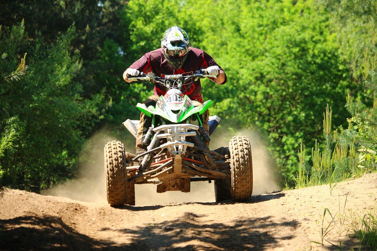 An image showcasing a Rhode Island ATV MAN, wearing a helmet and safety gear, confidently maneuvering through picturesque trails