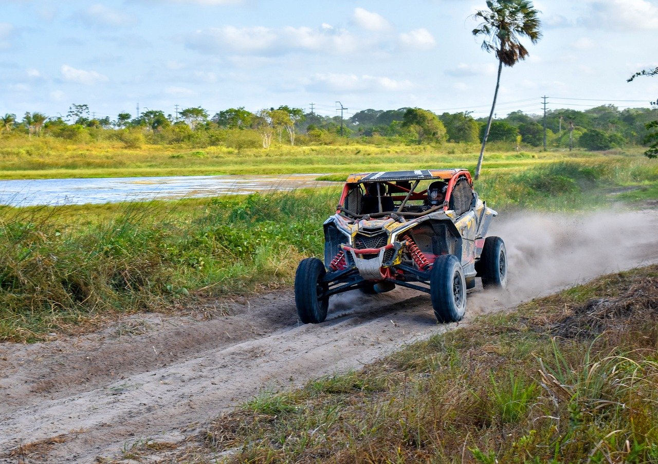 An image showcasing a rugged terrain with a UTV in motion, driven by an adventurous individual
